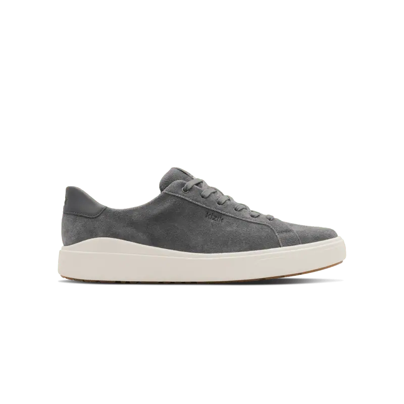 A gray suede Kizik lace-up sneaker with a white sole, shown from the side on a white background